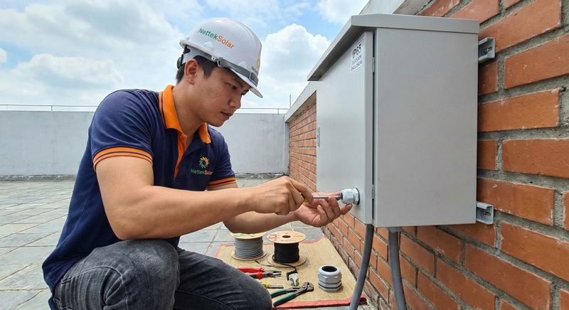 Kỹ thuật viên NettekSolar người việt nam thi công tủ điện chuẩn IP65 chịu mưa nắng